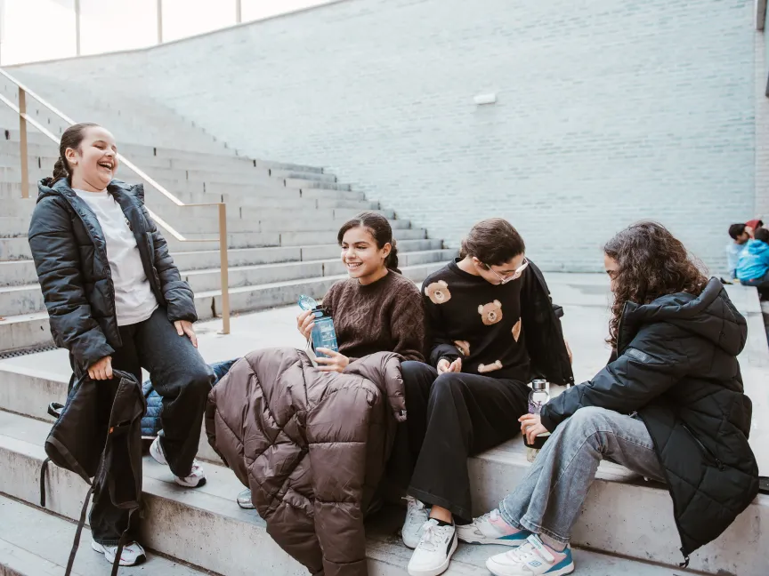 4 girls laughing with each other outside
